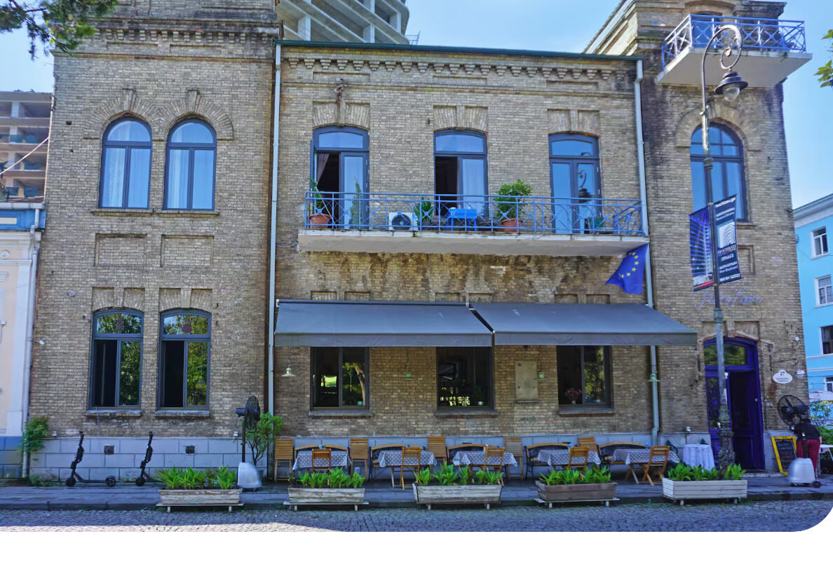 The Nakashidze Family House on Ninoshvili Street, Batumi — a two-storey brick façade with wrought-iron balconies and the Fanfan restaurant below.